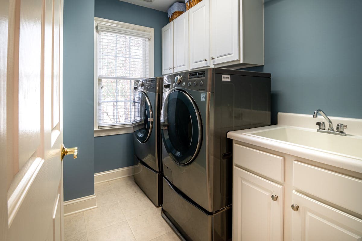 A clean, organized laundry room with a modern dryer